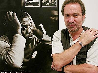 J�rgen Escher - Portrait mit Fl�chtling 2004, Lampedusa: 'Aufr�stung im Mittelmeer statt ernsthaften Bem�hens um L�sungen? Ich sch�me mich in diesem Moment, Europ�er zu sein.'
